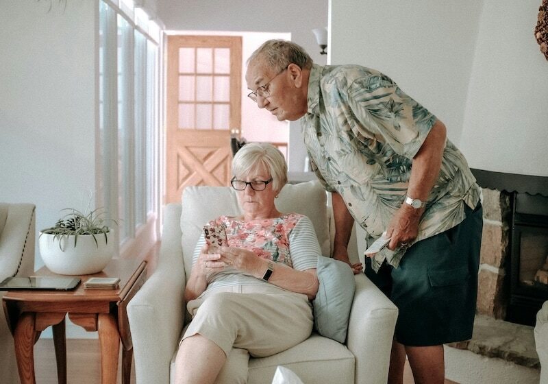 older couple at home looking at phone together